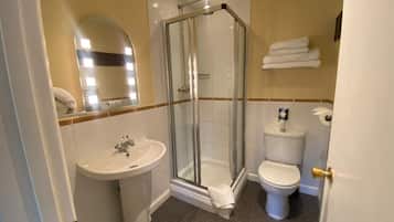 A bathroom with a glass-enclosed shower, a sink, and a toilet.
