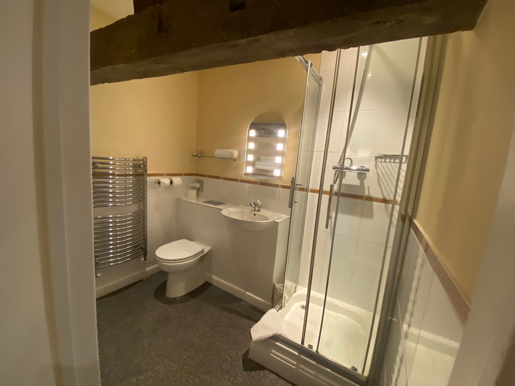 A bathroom with a toilet, sink, and glass-enclosed shower.