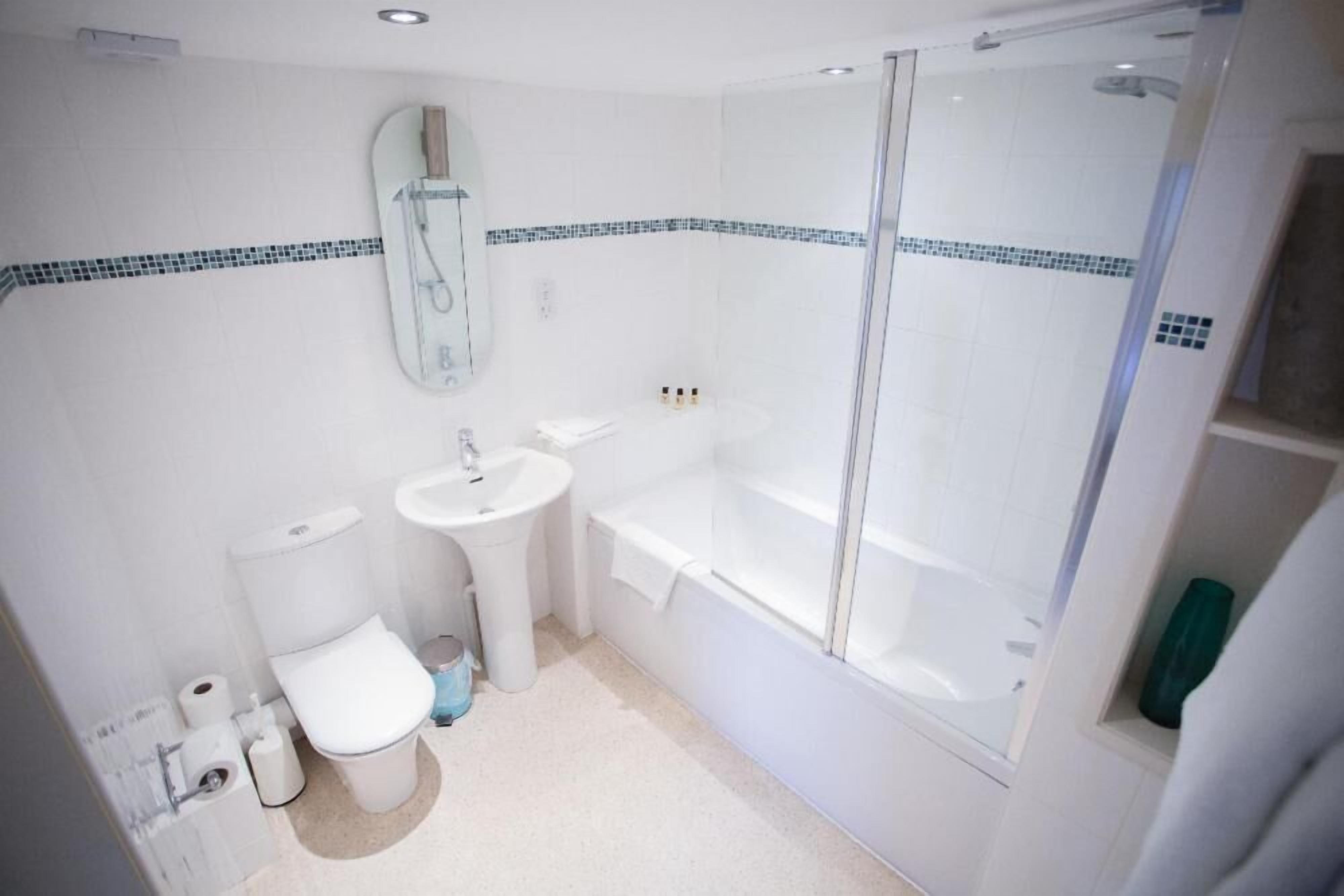 A bathroom with a toilet, sink, bathtub, and shower.