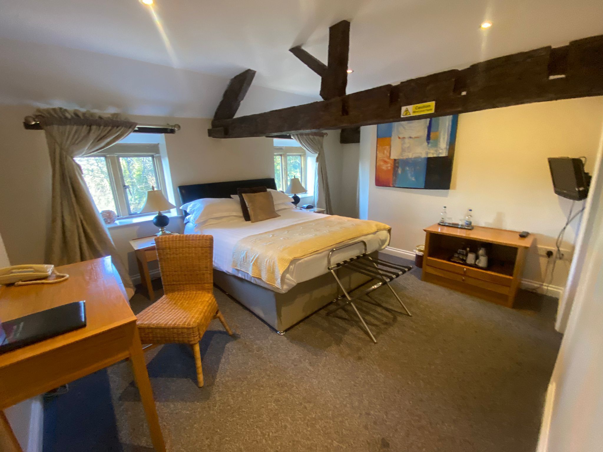 A bedroom with a bed, a chair, a desk, a shelf, and a window.