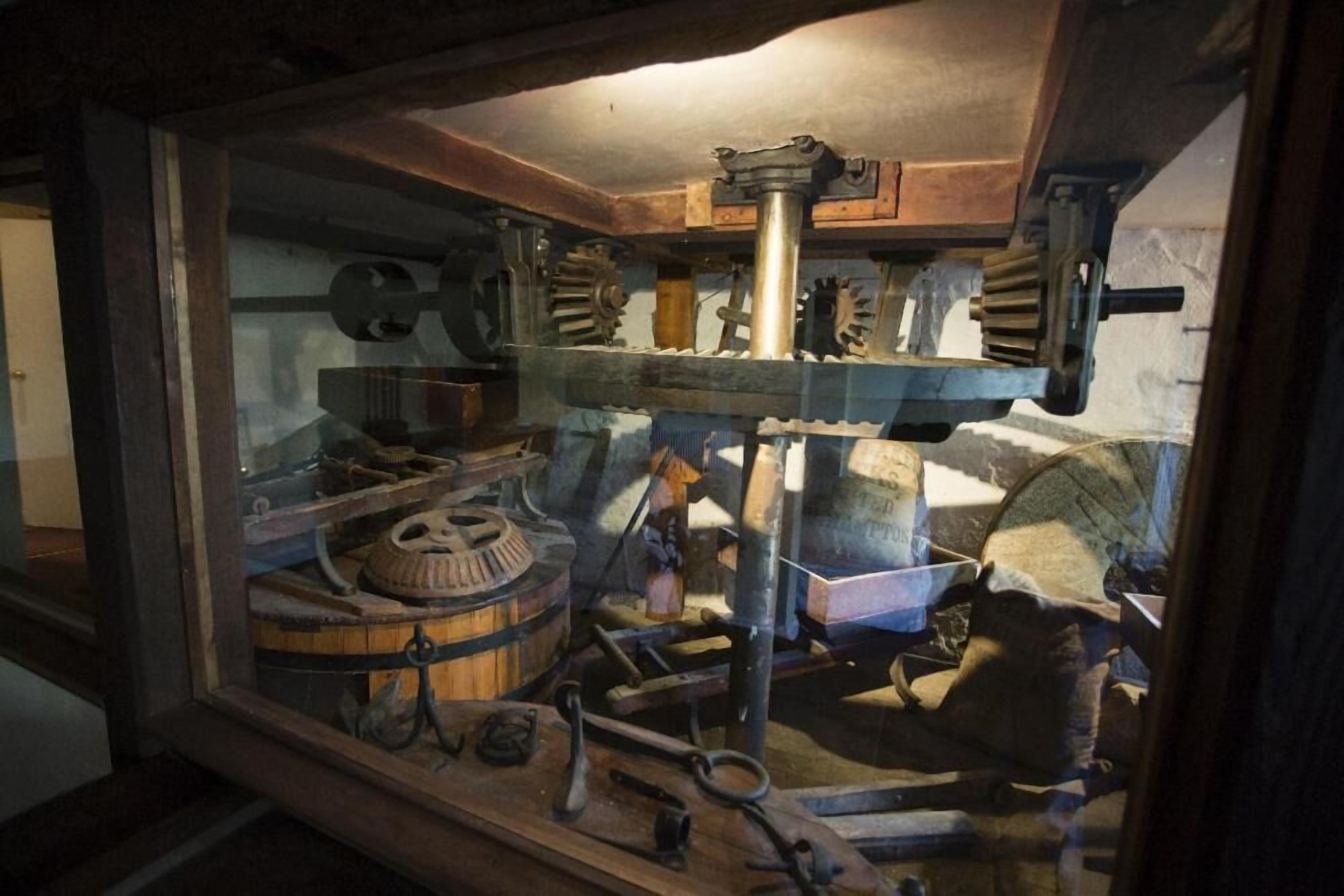 Een historisch mechanisch display met tandwielen en gereedschap.