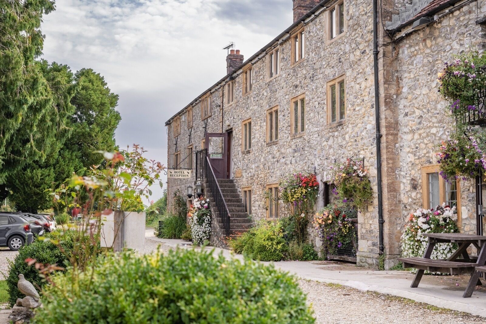 A stone building with a reception area, a staircase, and flower arrangements.