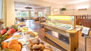 A buffet area with a variety of fruits, breads, and pastries. - Flair Hotel Rieckmann (Bispingen)