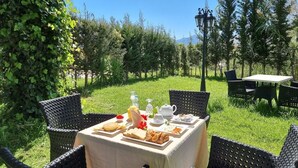 An outdoor dining area with wicker chairs and a table set for breakfast. - Hôtel El Yacouta (Tetouan)