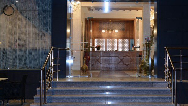 A hotel lobby with a reception desk, a staircase, and a decorative wall. - Hôtel El Yacouta (Tetouan)