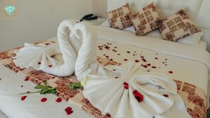 A hotel room with a neatly made bed, a telephone, and decorative pillows. - Hôtel El Yacouta (Tetouan)