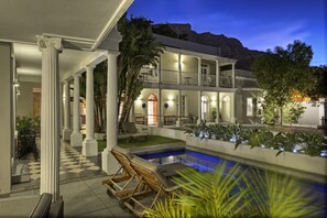 A two-story building with a pool, columns, and outdoor seating. - The Three Boutique Hotel (Cape Town)