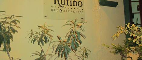 A sign for Quinta Rufino bed and breakfast with a lamp above it.
