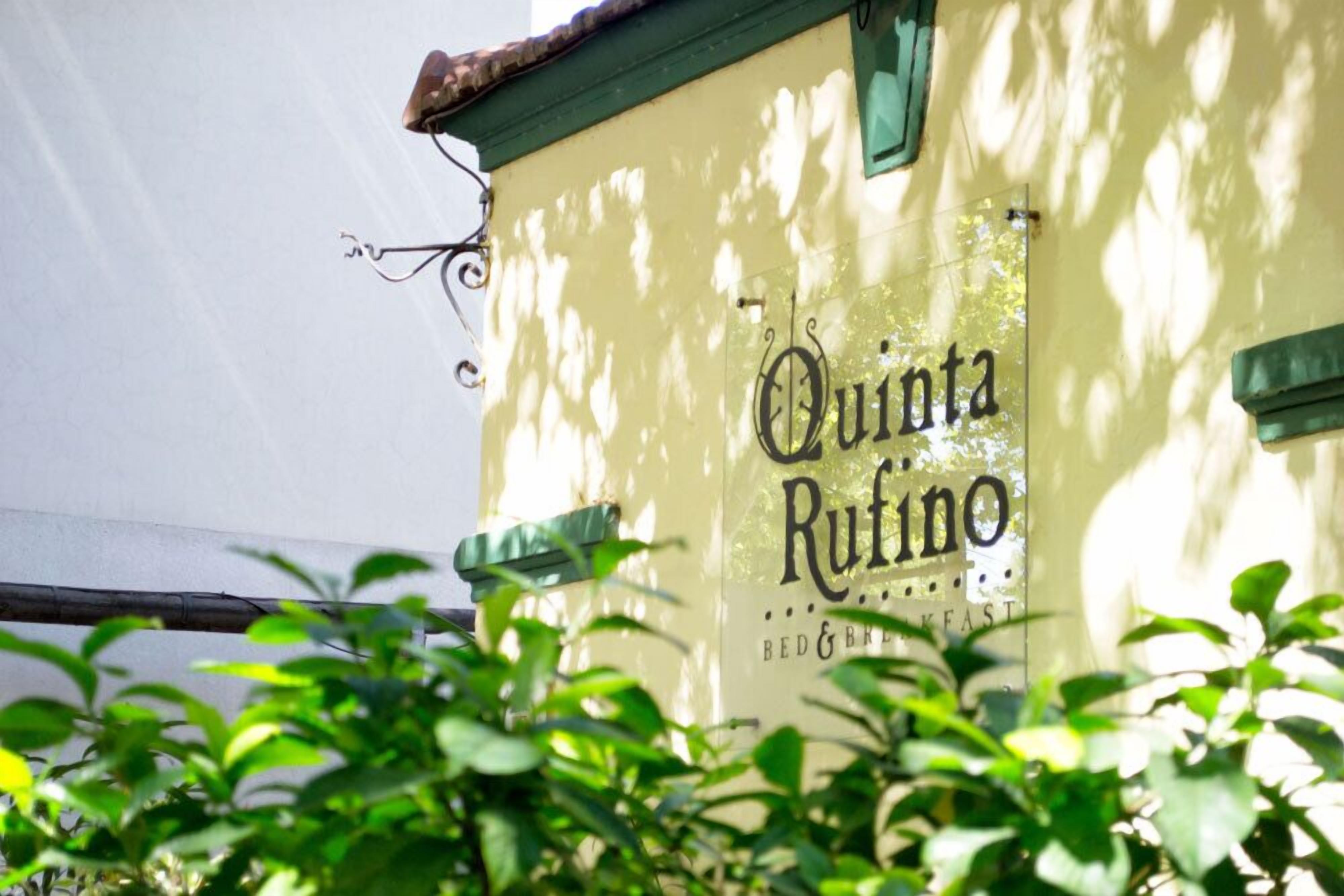 A building with a sign that reads "Quinta Ruino" and a green awning.