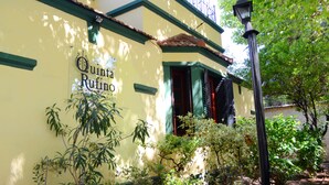 Un edificio amarillo con el letrero "Quinta Ruino" y detalles en verde.