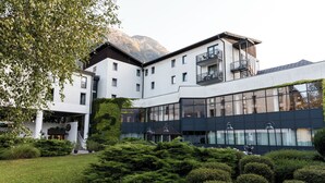 Un edificio moderno con varios pisos, ventanas amplias y un balcón.