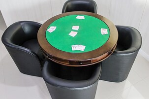 Una mesa de póker con cartas y sillas alrededor.