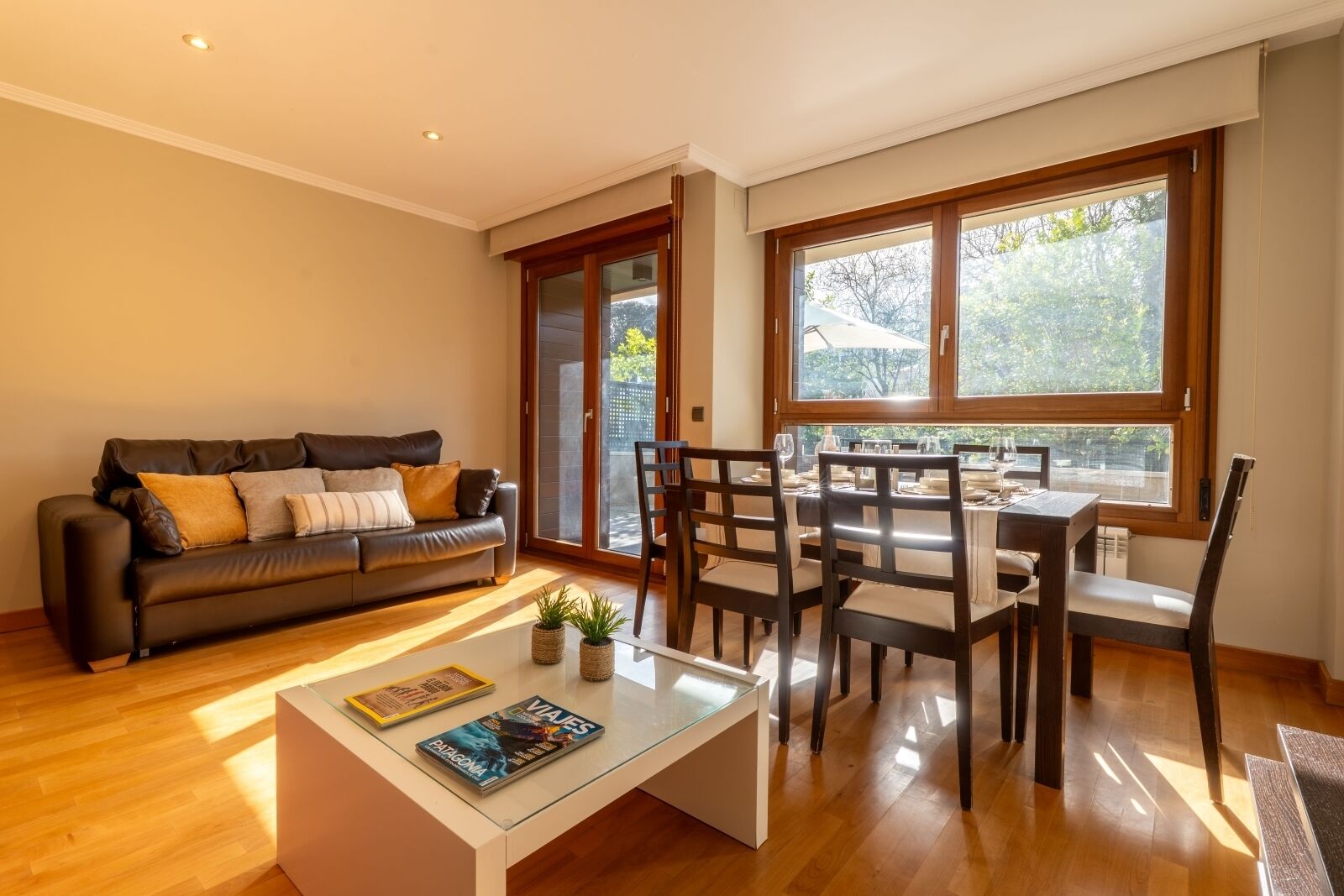 Una sala de estar moderna con sofá, mesa de centro y comedor.