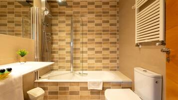 A modern bathroom with a glass-enclosed shower, a bathtub, and a toilet.