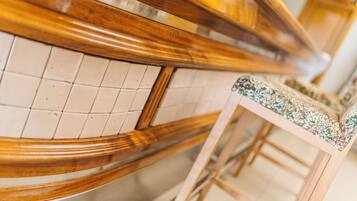 Una barra de madera con un rebozo de azulejos y un taburete con asiento estampado.
