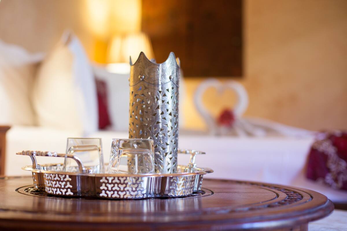 A tray with glassware and a decorative metal piece on a wooden table.