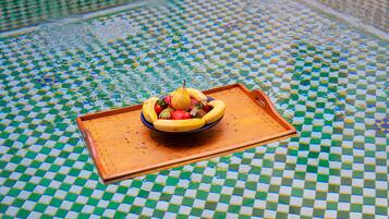 Un suelo de baldosas a cuadros con una bandeja que contiene un cuenco de fruta.