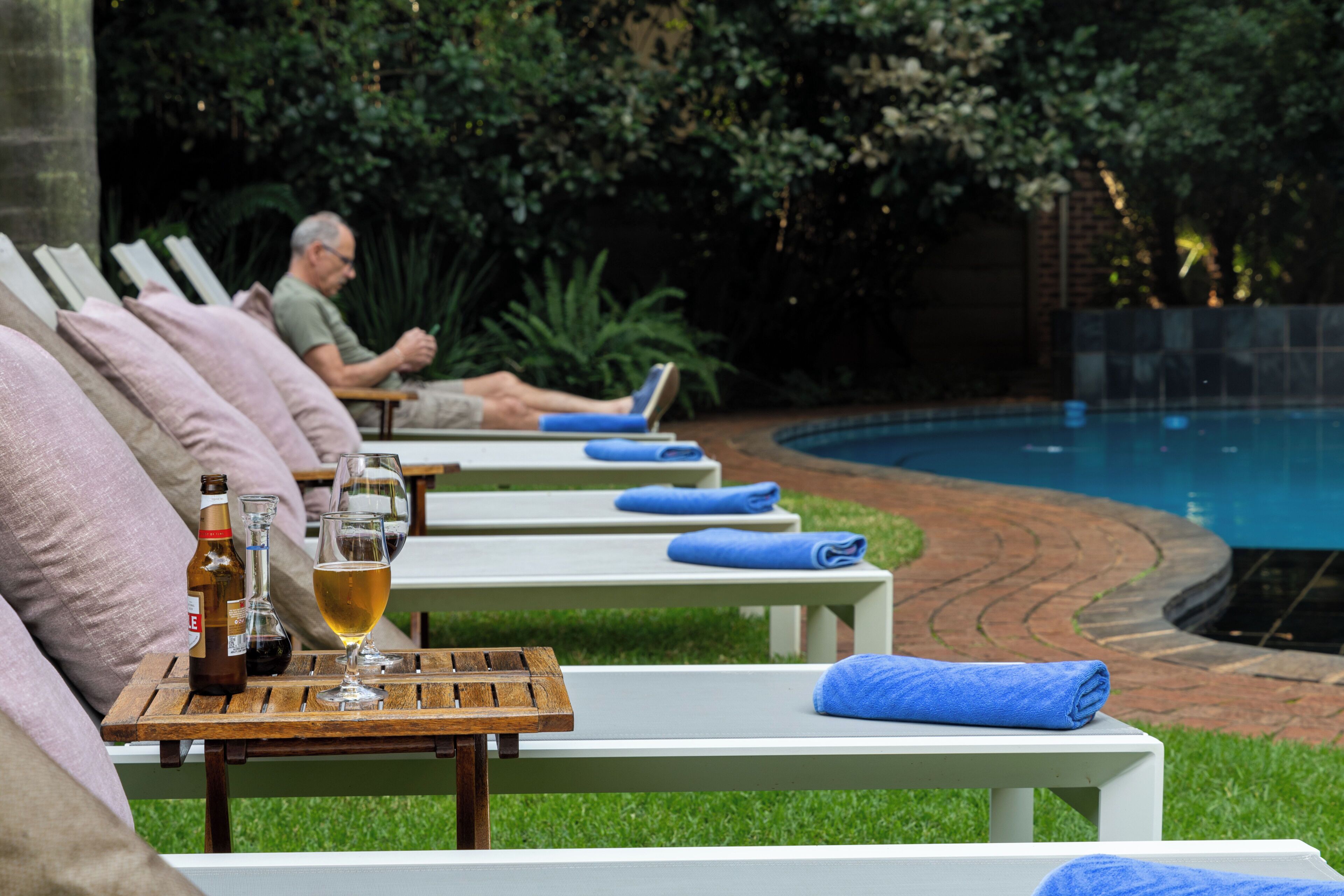 Una piscina al aire libre, sillones reclinables de piscina