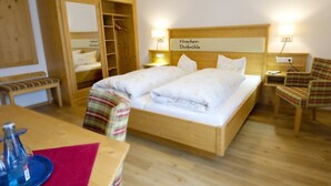 Een bed met houten frame en hoofdbord waarop 