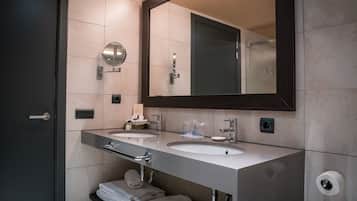 Un baño moderno con dos lavamanos, un espejo grande y un perchero para toallas.