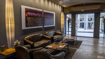 A modern lobby with leather sofas, a wooden coffee table, and artwork on the wall.