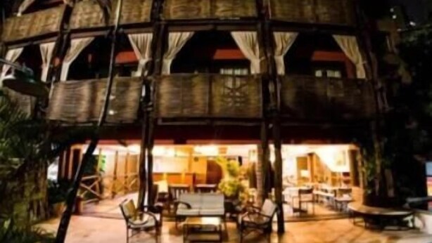 A two-story building with a circular central courtyard, outdoor seating, and a pool. - Safari Natal Beach Hotel (Natal)
