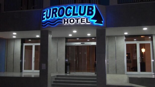The exterior of the EuroClub Hotel with a prominent illuminated sign, a glass entrance, and a staircase leading to the entrance. - Euro Club Hotel (St. Paul's Bay)