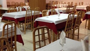 A dining area with tables set for service, each with a white tablecloth and red napkins. - Euro Club Hotel (St. Paul's Bay)