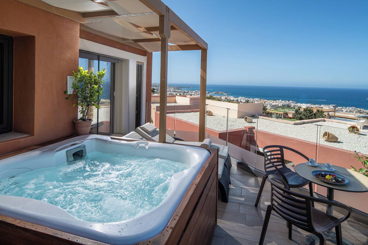 A hot tub on a balcony with a view of the sea.