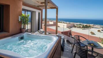 A hot tub on a balcony with a view of the sea.