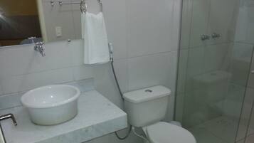 Un baño con lavamanos, inodoro y ducha.