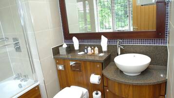 A bathroom with a white sink, wooden vanity, and a large mirror.