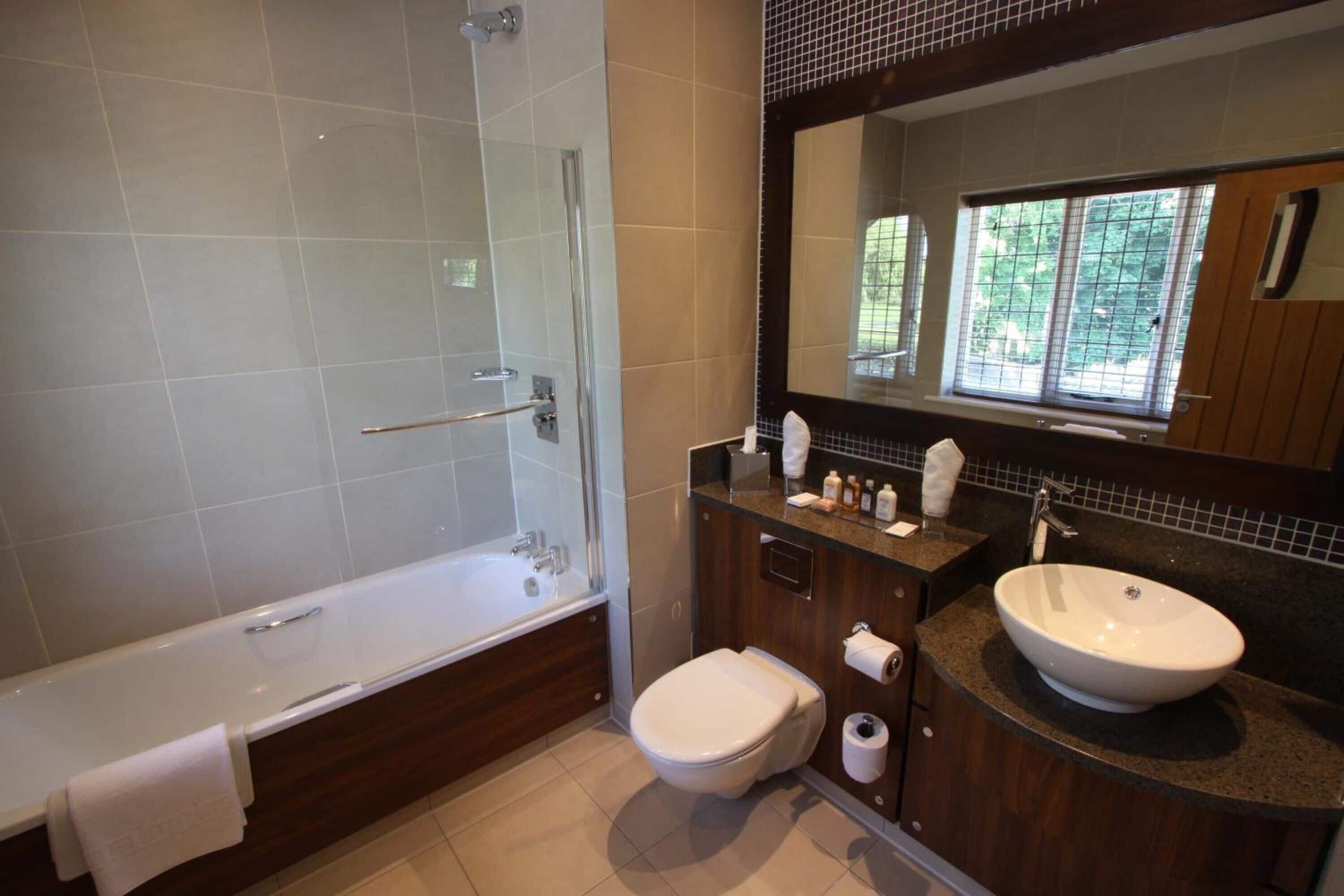 A modern bathroom with a bathtub, toilet, and sink.