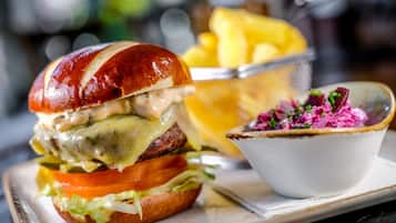 A burger with a side of fries and a bowl of coleslaw.