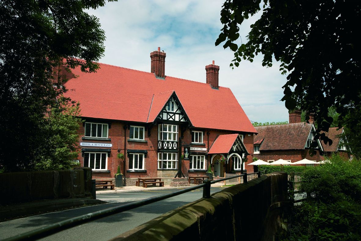 A traditional red-roofed building with a sign reading "HOTEL & RESTAURANT."