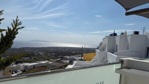 Un balcon d’hôtel offrant une vue sur la mer et les bâtiments situés au loin.