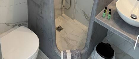 A bathroom with a shower, toilet, and sink.
