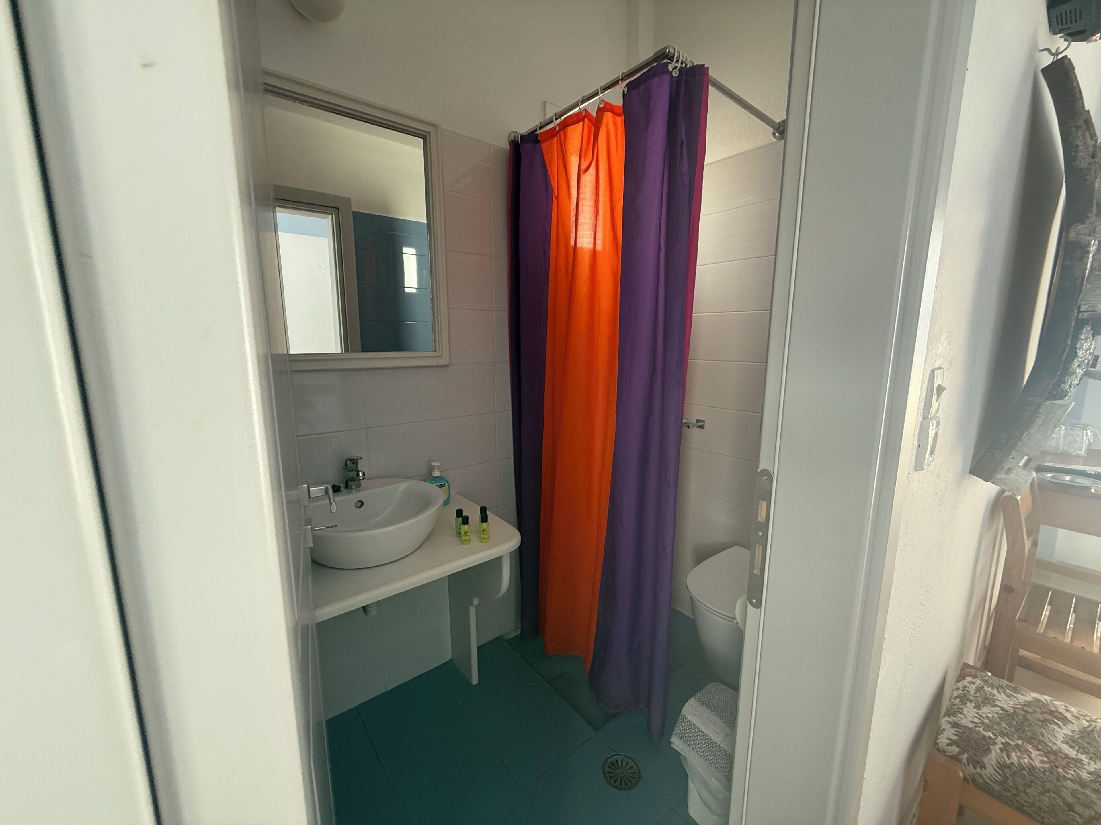 Ein Badezimmer mit Waschbecken, Spiegel und Duschvorhang.