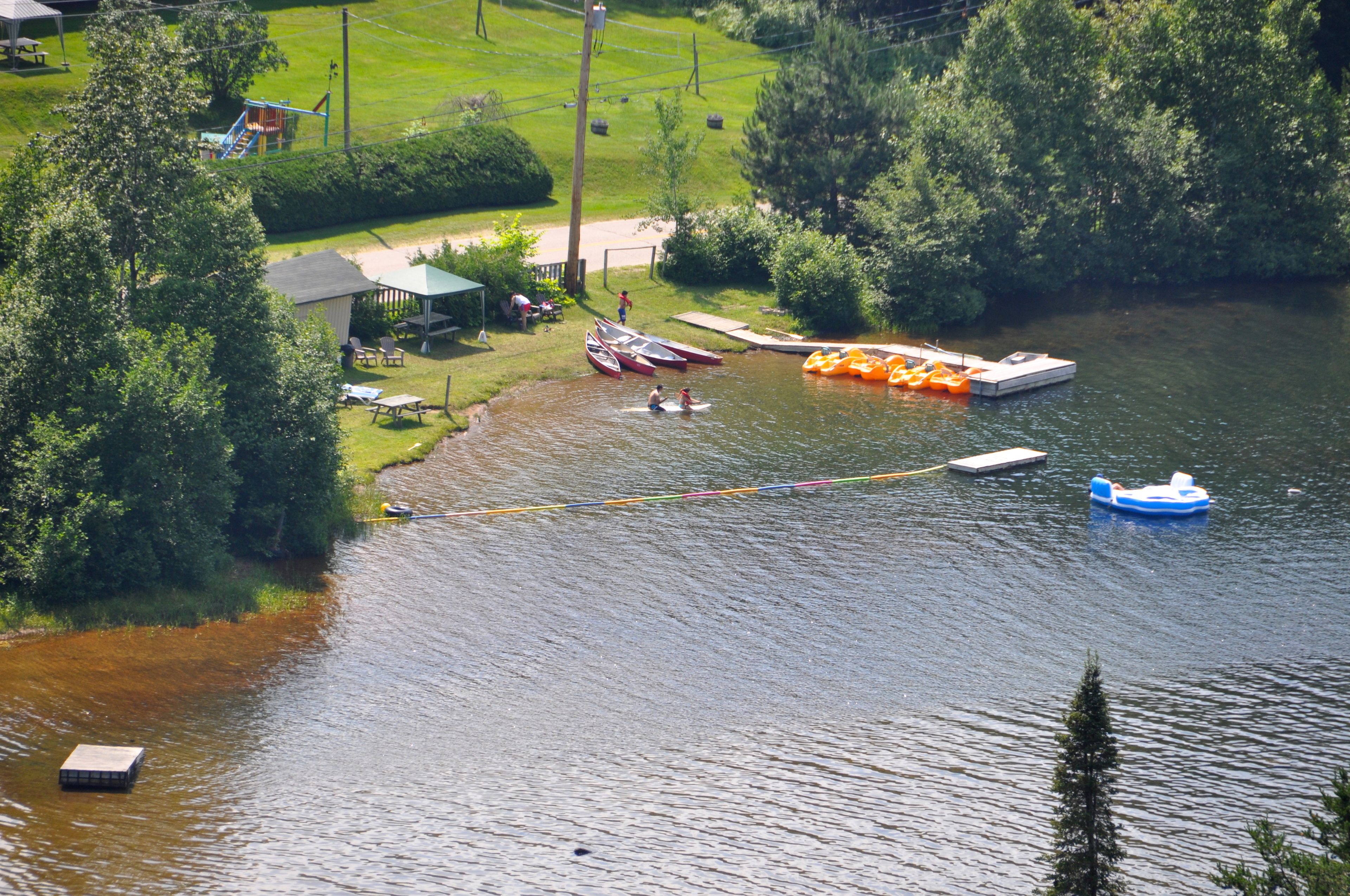 A riverside area with boats, a dock, and a playground.