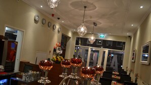 Recepció d'hotel amb taulell d'entrada, zona de seients i un penjoll decoratiu.