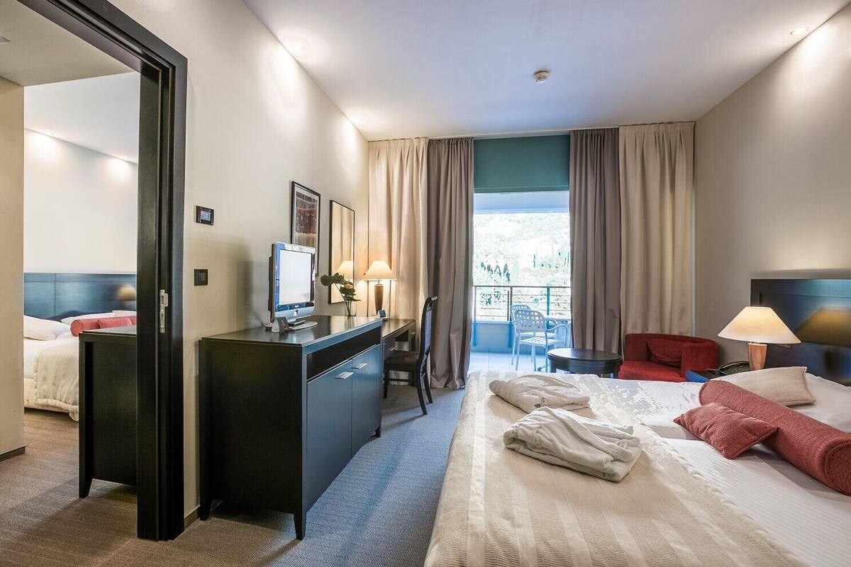 Une chambre d’hôtel équipée d’un lit, d’un bureau, d’une chaise et offrant une vue sur l’extérieur.