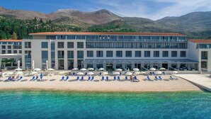 Un hôtel doté d’un espace autour de la piscine, de chaises longues et de parasols.