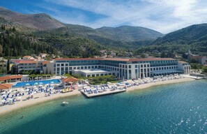 Un complexe hôtelier doté d’une grande piscine, d’une plage et offrant une vue sur les montagnes.