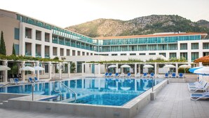 Un hôtel doté d’une piscine, de chaises longues et de parasols.