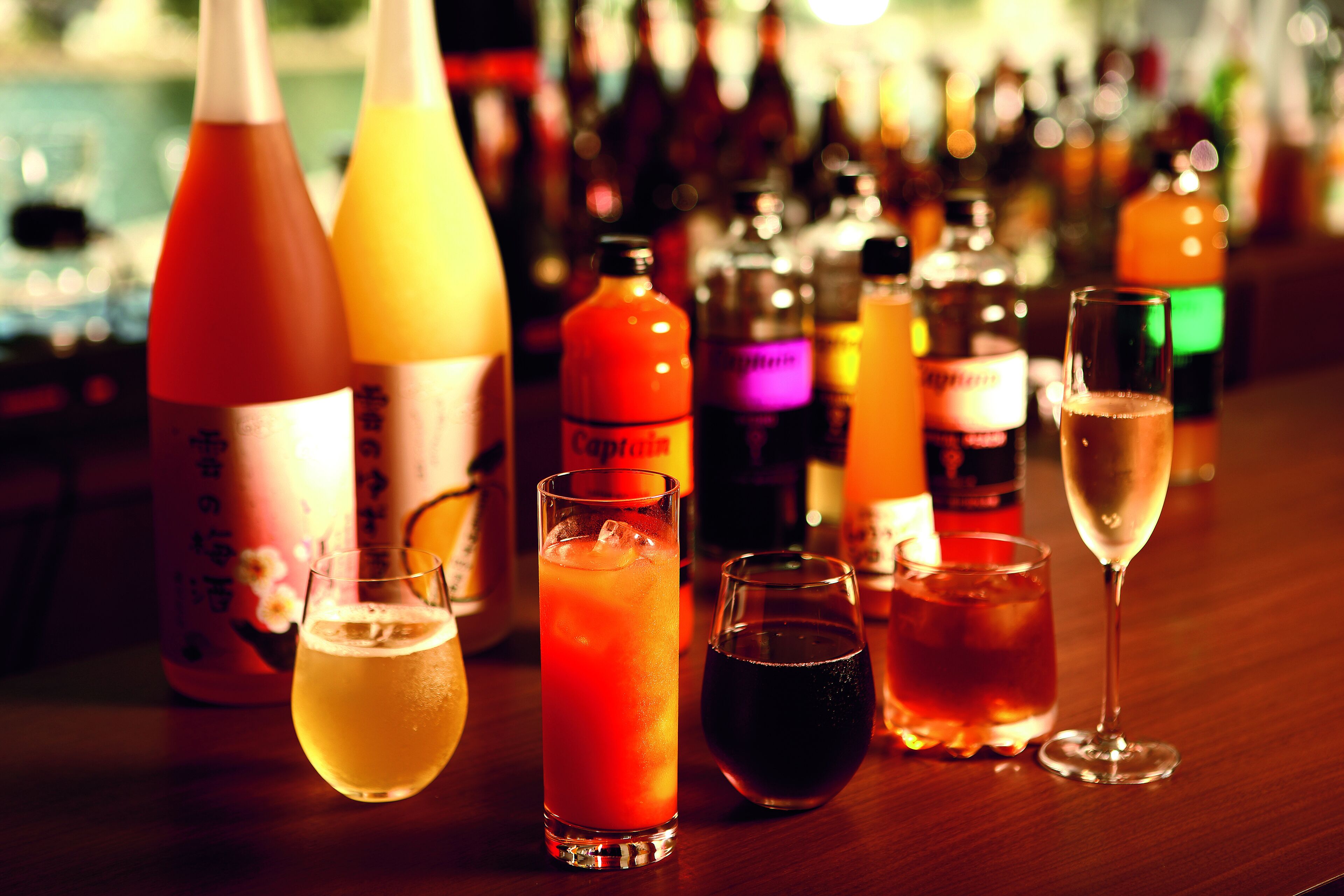 A bar with various bottles and glasses of drinks.