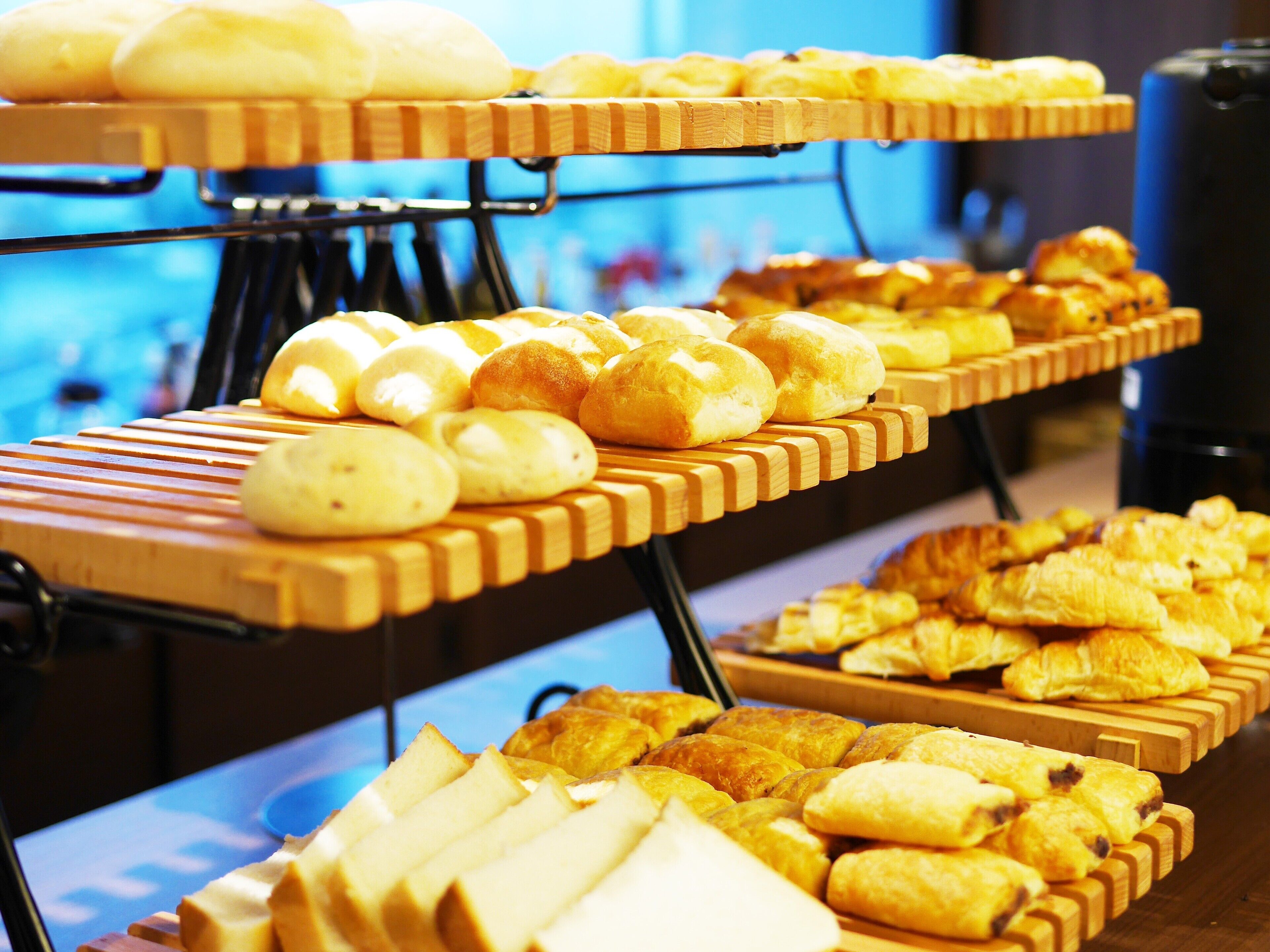 Un buffet proposant une variété de produits de boulangerie, notamment du pain, des petits pains et des viennoiseries.