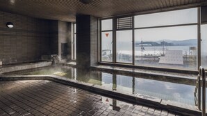 Una gran piscina cubierta con vistas a un paisaje urbano a través de amplias ventanas.