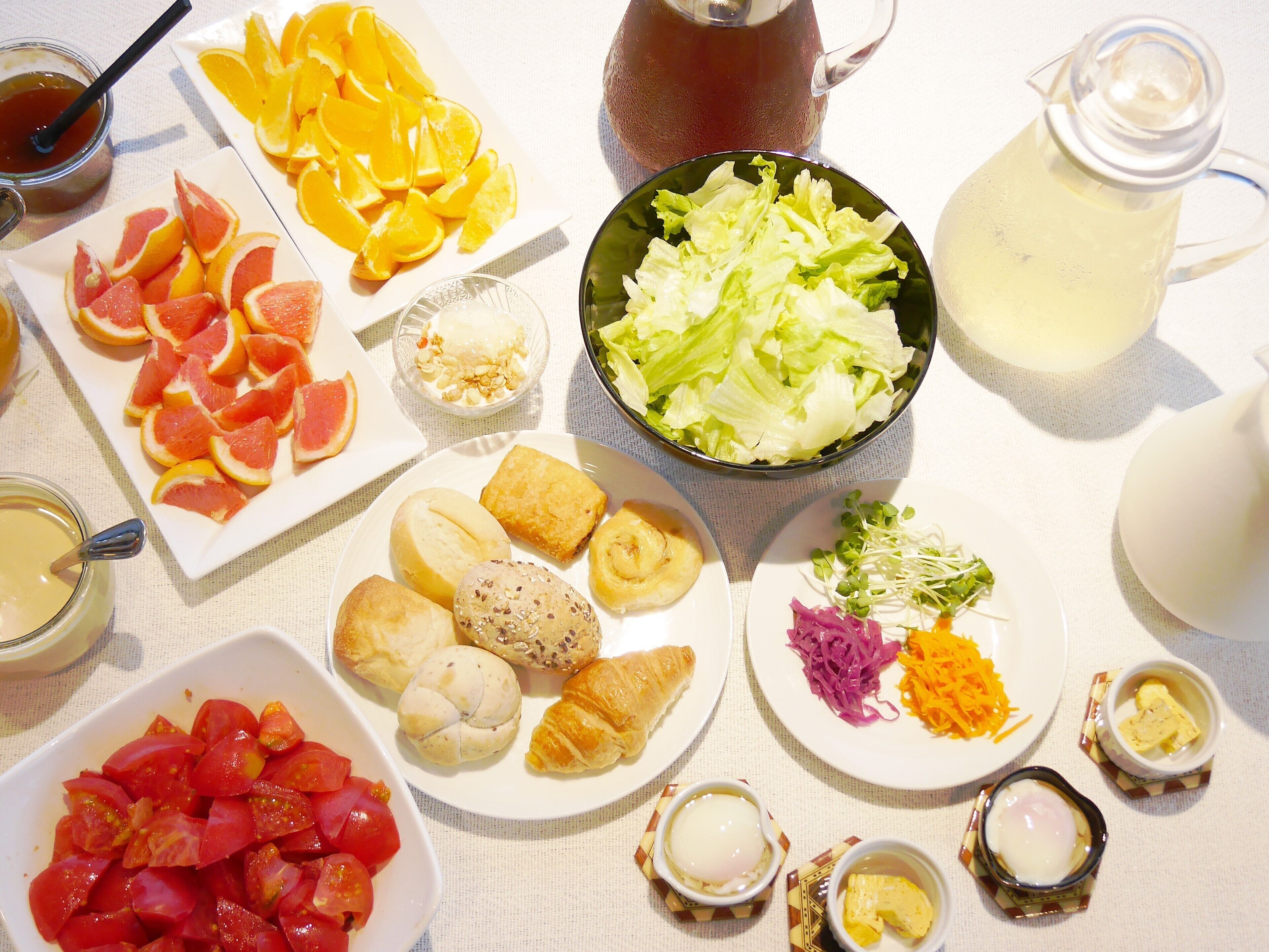 A table with various food items including fruits, vegetables, and bread.