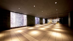 A corridor with tiled flooring, recessed lighting, and patterned glass walls. - Hotel Asia Center of Japan (Tokyo)