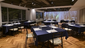 A conference room with multiple tables set for meetings, equipped with chairs, tables, and projection screens. - Hotel Asia Center of Japan (Tokyo)